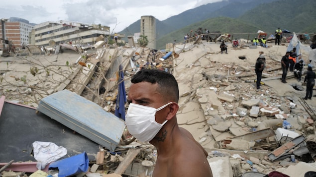 Un bénévole observe les opérations de recherche des victimes dans les décombres des bâtiments effondrés à Caraballeda, dans l'État de La Guaira, au Venezuela, le 28 juin 2026.