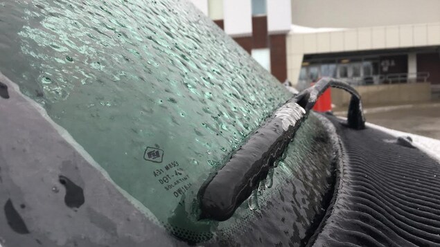 Une épaisse couche de verglas sur le pare-brise d'un véhicule Une épaisse couche de verglas sur le pare-brise d'un véhicule
