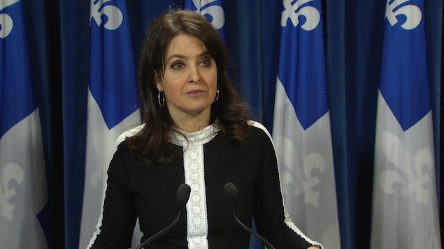 Véronique Hivon devant des drapeaux du Québec.