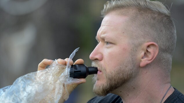 Un homme fume de la marijuana à l'aide d'un masque vapoteur Un homme fume de la marijuana à l'aide d'un masque vapoteur