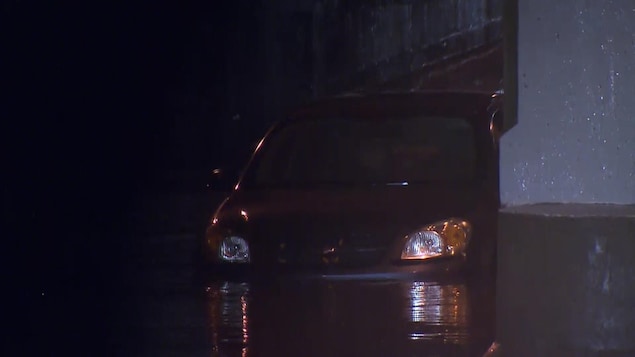 Une voiture est dans l'eau jusqu'aux phares. Une voiture est dans l'eau jusqu'aux phares.