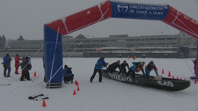 Les canoéistes de l'équipe Volvo atteignent la ligne d'arrivée de la course de canot à glace.