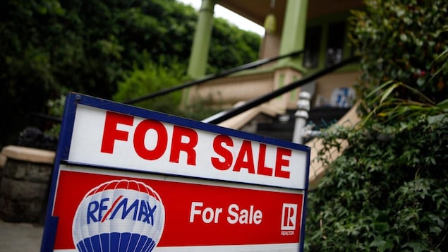 Isang "For Sale" sign sa harap ng bahay.