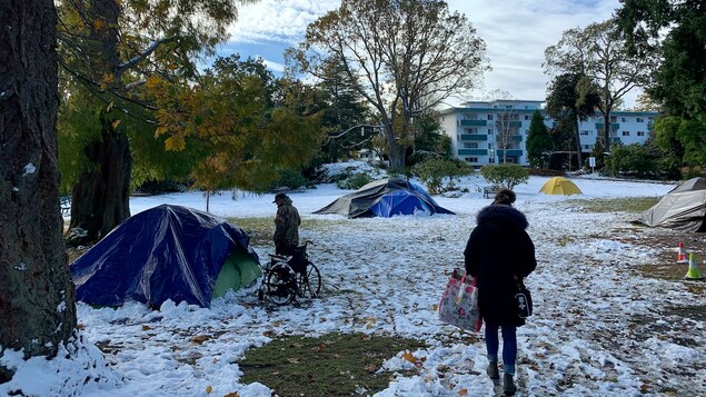 Un parc avec des tentes érigées dans la neige à Victoria. 