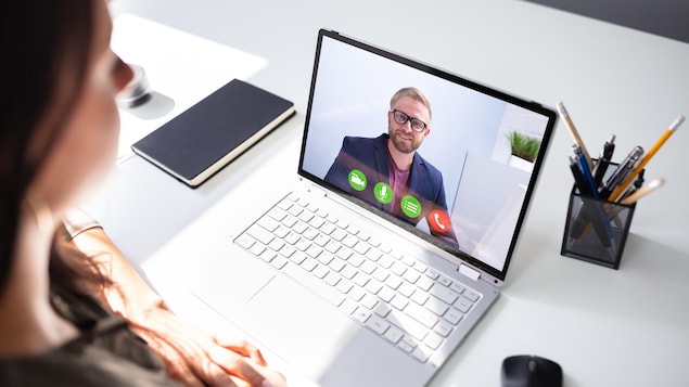 Une femme en appel vidéo avec un homme, sur son ordinateur.