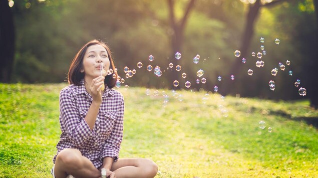 Une jeune femme fait des bulles. 