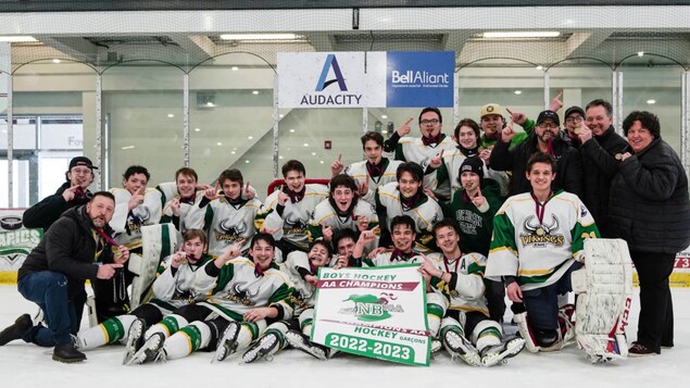 Les joueurs des Vikings de l'école Marie-Esther de Shippagan posent avec la banderole de champions.