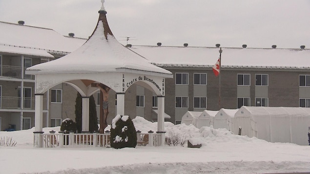 L'extérieur de la résidence en hiver, avec des abris pour auto dehors.