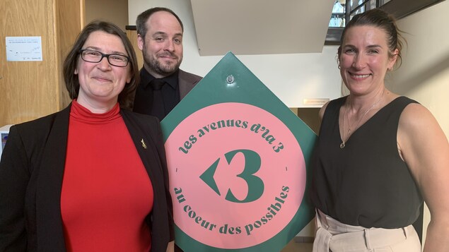 Trois personnes sourient à la caméra.