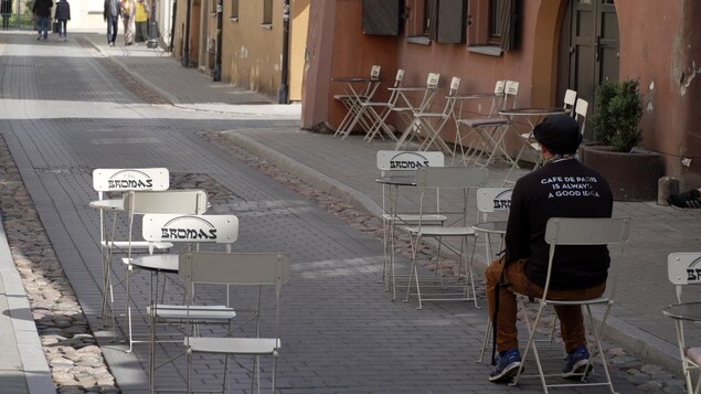 Un client assis à une table montée en plein rue.