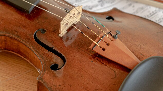 Le violon est déposé sur une partition près de l'archet.