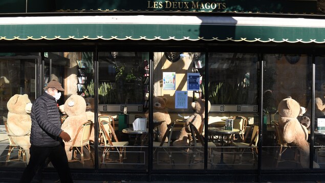 Un homme passe devant le café Les Deux Magots, à Paris.