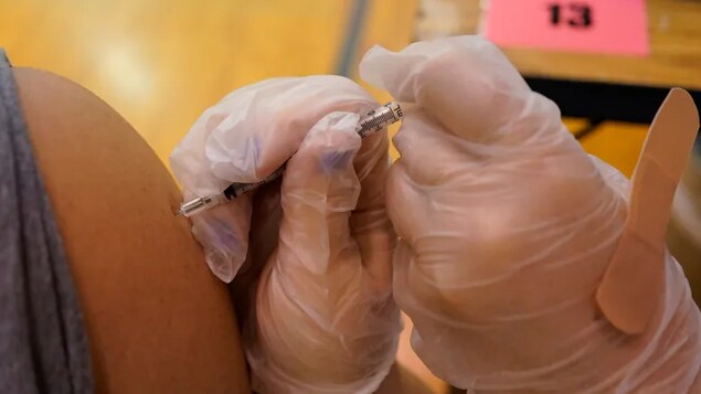 A health-care worker administrates a dose of the Pfizer-BioNTech COVID-19 vaccine to an eligible student in Illinois. The exact timing of when younger children will be eligible for COVID-19 vaccines in the U.S. and other countries is not yet clear.