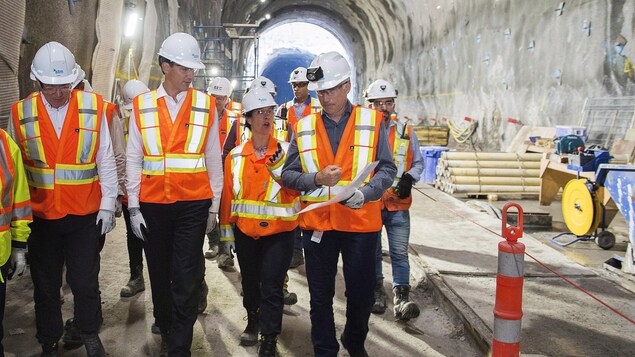 M. Trudeau et Mme Plante, entourés d'autres dignitaires, regardent les travaux.