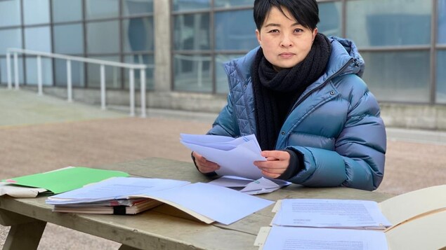 Vivien Zheng tient des documents.