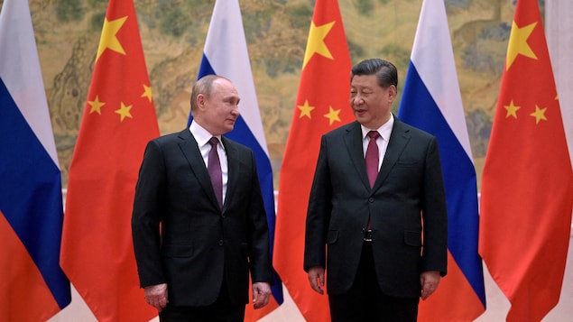 Vladimir Poutine et Xi Jinping devant des drapeaux russes et chinois.