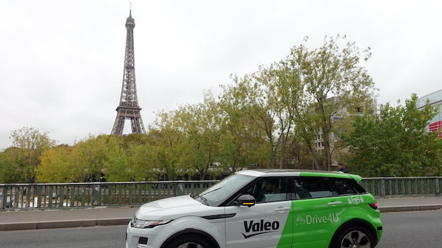 Une voiture autonome devant la tour Eiffel