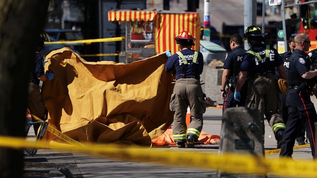 Des pompiers couvrent une victime happée par une fourgonnette, qui a heurté plusieurs personnes à Toronto. Des pompiers couvrent une victime happée par une fourgonnette, qui a heurté plusieurs personnes à Toronto.