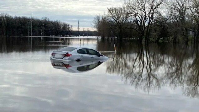 Une voiture en partie submergée par les eaux. 
