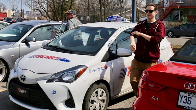 On aperçoit un jeune homme et son instructeur. Ils sortent d’une voiture aux couleurs du Groupe Tecnic. On aperçoit un jeune homme et son instructeur. Ils sortent d’une voiture aux couleurs du Groupe Tecnic.