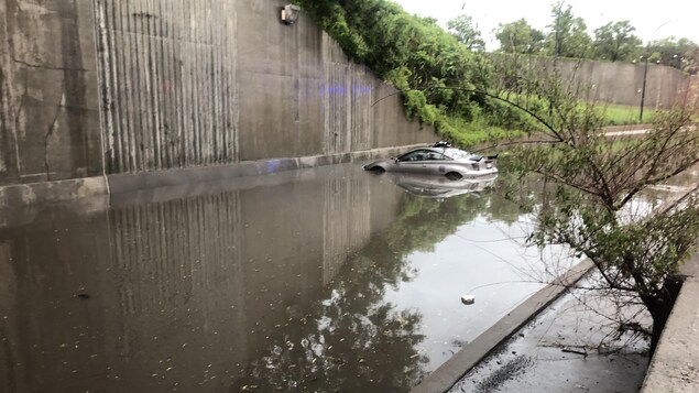 Une voiture sur une voie inondée dans l'échangeur.