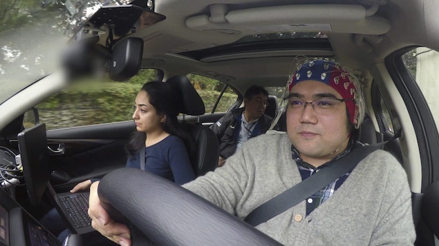 Un conducteur porte un casque qui lit ses ondes cérébrales alors qu'il est au volant d'un véhicule Nissan. Un conducteur porte un casque qui lit ses ondes cérébrales alors qu'il est au volant d'un véhicule Nissan.