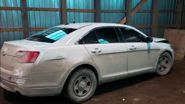 Une Ford Taurus 2013 blanche dans un entrepôt.