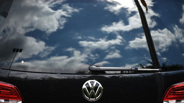Le reflet du ciel nuageux sur la vitre arrière d’un véhicule du constructeur automobile allemand Volkswagen (VW).