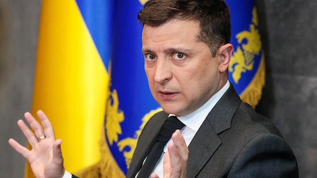  Volodymyr Zelensky, devant un drapeau ukrainien, gesticulant