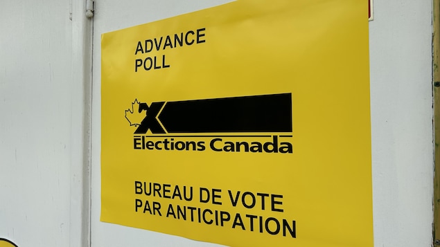 Une affiche jaune d'Élections Canada annonçant un bureau de vote par anticipation.