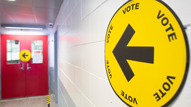 Une affiche indiquant l'entrée d'un bureau de vote.