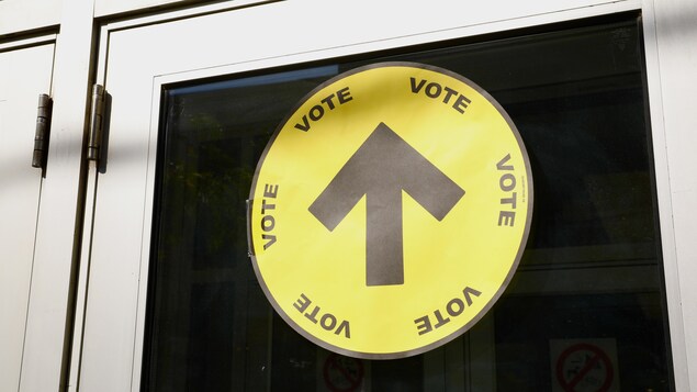 Une affiche qui dit « vote » collée dans une porte.