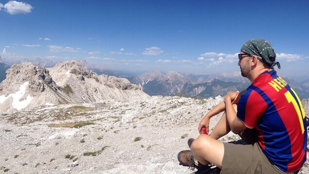 André Larouche assis et profitant de la vue à 360 degrés sur les Dolomites, en Italie