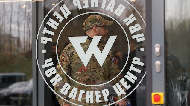Un homme portant un uniforme de camouflage entre dans les bureau du groupe militaire privé Wagner, à Saint-Pétersbourg.