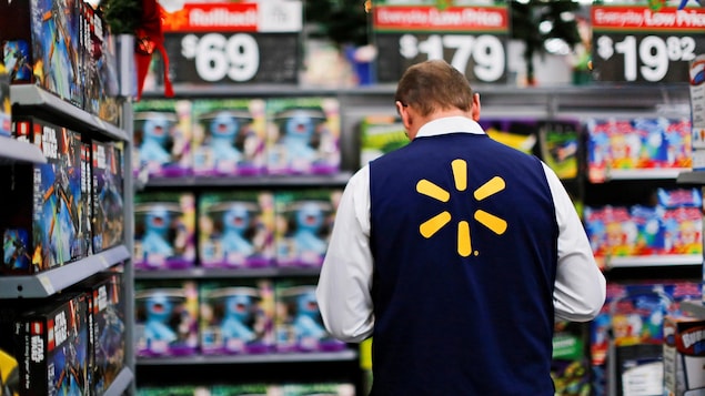Un employé parmi des jouets dans un magasin de Walmart.