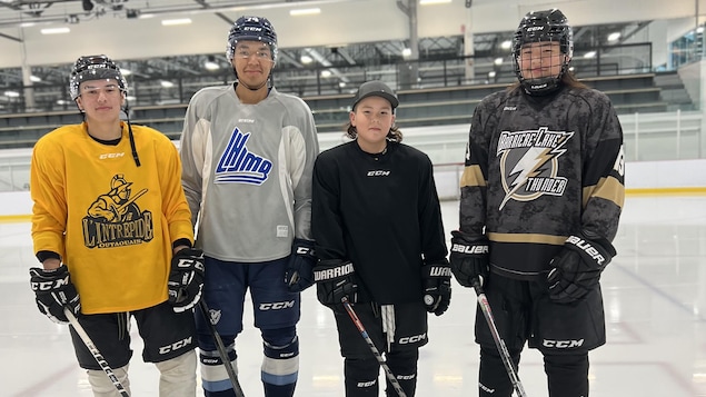 Quatre hockeyeurs de la même famille posent pour la caméra.