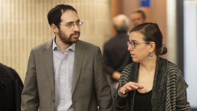 Deux personnes marchent dans un corridor du palais de justice de Montréal.