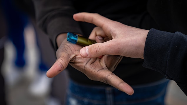 deux jeunes s'échangement une vapoteuse.