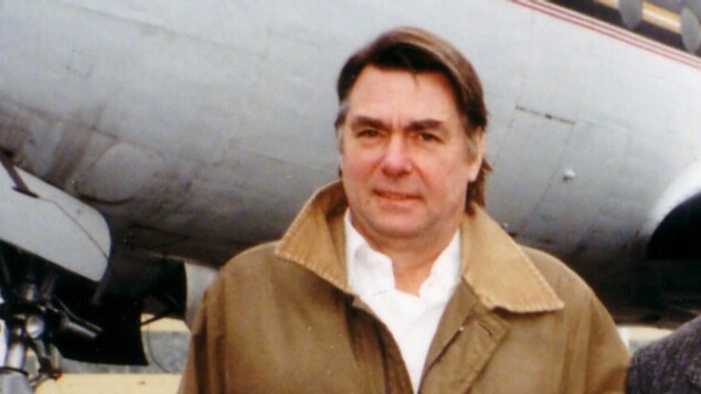 Photo de Wayne Millard posant devant un avion. Photo de Wayne Millard posant devant un avion.