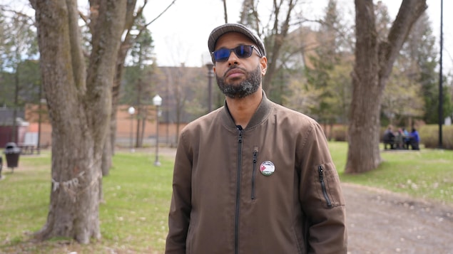 Un homme prend la pose dans un parc, au printemps.