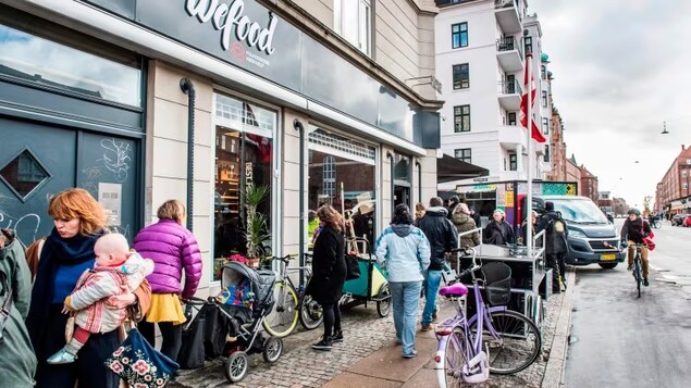 People walk past a Wefood supermarket in Copenhagen in 2016. The supermarket sells deeply discounted food items that are damaged or near expiry. (Soeren Bidstrup/AFP via Getty Images)