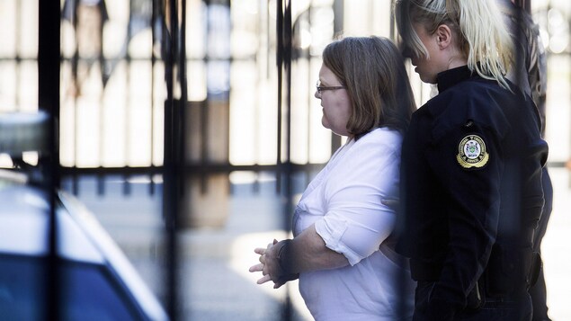 Photo de Wettlaufer qui est suivie par une policière alors qu'elle se dirige vers le tribunal.