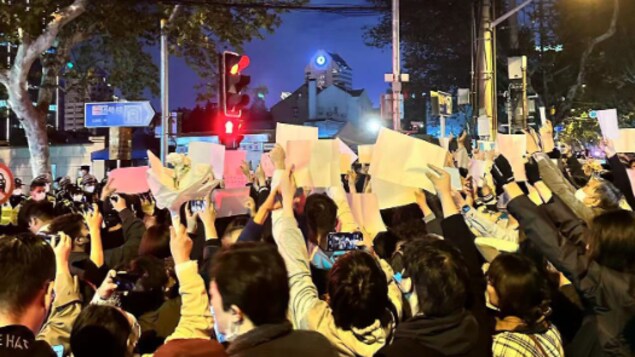 2022年11月27日,上海烏魯木齊中路入口,民眾舉起白紙抗議。