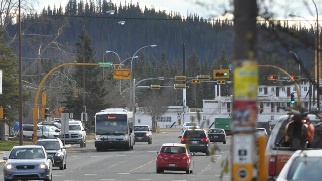 Un bus et des voitures en circulation dans un boulevard parsemé de feux de circulation.