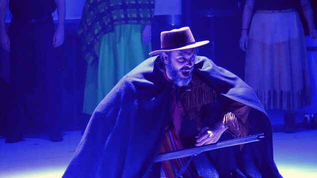 Le comédien Charles Bender incarne le personnage de Gabriel Dumont. Il arbore des habits de cowboy et tient un fusil en mains en lâchant un cri. Le comédien Charles Bender incarne le personnage de Gabriel Dumont. Il arbore des habits de cowboy et tient un fusil en mains en lâchant un cri.