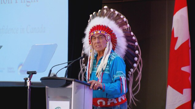 Dans l'image: Wilton Littlechild, grand chef du Traité 6 en train de prononcer un discours au pupitre devant une assemblée de près de 300 personnes. Dans l'image: Wilton Littlechild, grand chef du Traité 6 en train de prononcer un discours au pupitre devant une assemblée de près de 300 personnes.
