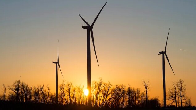 Wind turbines spin in front of the setting sun near Orono, Ont., in 2017. While most of Canada's electricity is already from non-emitting sources like hydropower, nuclear and wind, the International Energy Agency says much more clean electricity will be needed to meet climate goals.