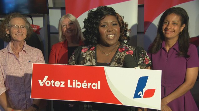 Wittlyn Kate Semervil et des membres du Parti libéral du Québec sur une scène lors d'un point de presse.