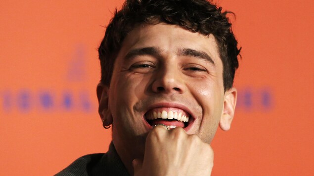Xavier Dolan sourit à pleines dents.