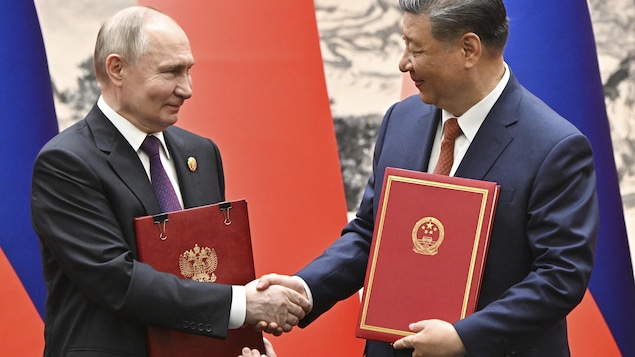 中国国家主席习近平（右）与俄罗斯总统普京握手。